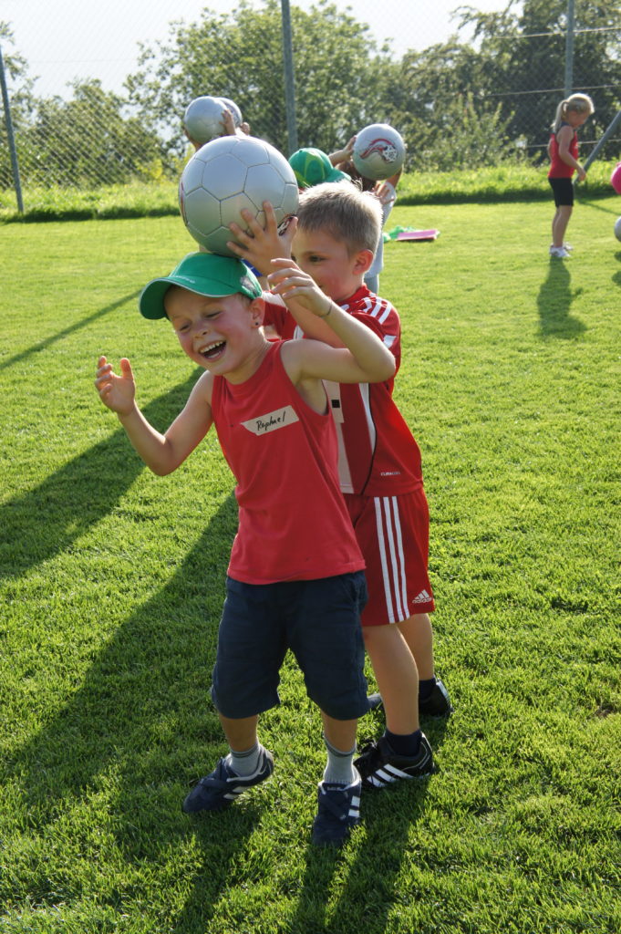 Kinder spielen Ball